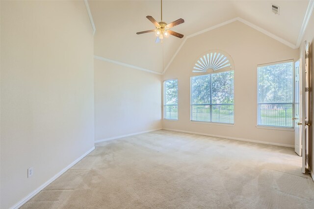 empty room with vaulted ceiling, a healthy amount of sunlight, ceiling fan, and light carpet