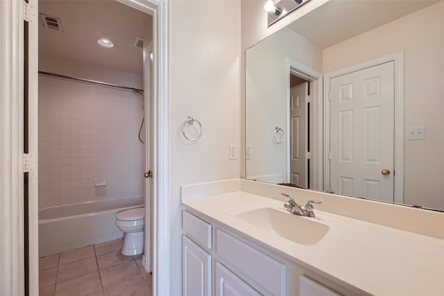 full bathroom featuring toilet, tile patterned flooring, tiled shower / bath, and vanity