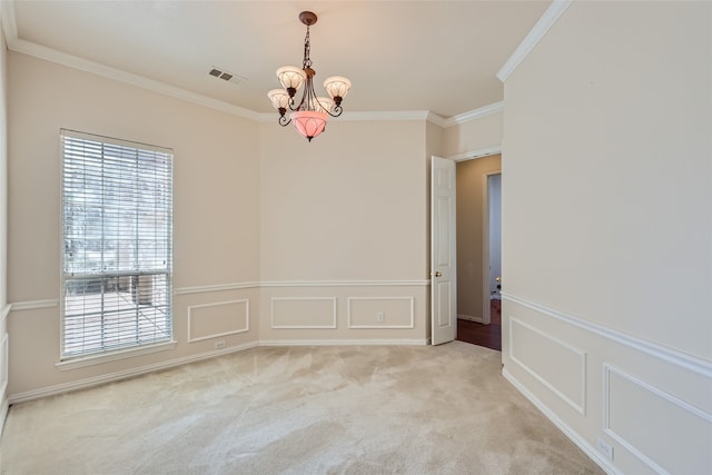 empty room with an inviting chandelier, crown molding, and light colored carpet