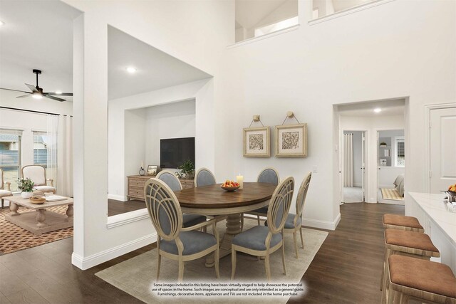 dining area with ceiling fan, dark wood-type flooring, and a high ceiling