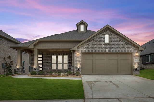 view of front of property featuring a yard and a garage