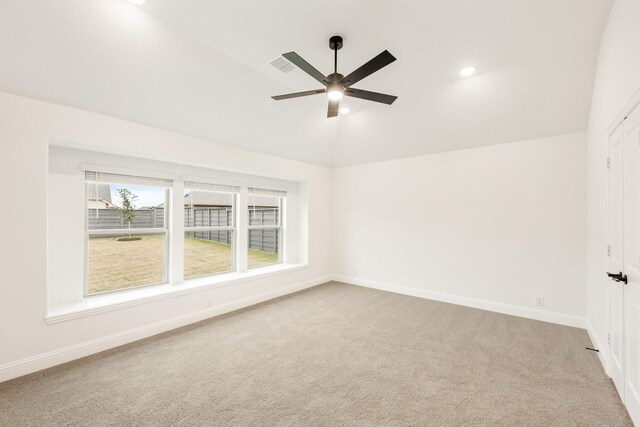 empty room with ceiling fan, light carpet, and vaulted ceiling