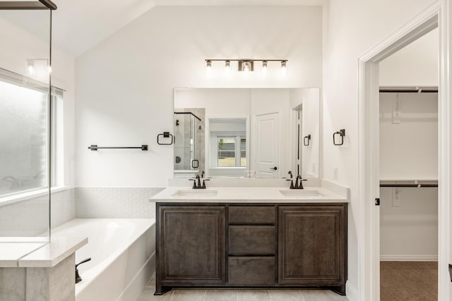 bathroom with vanity, independent shower and bath, and vaulted ceiling