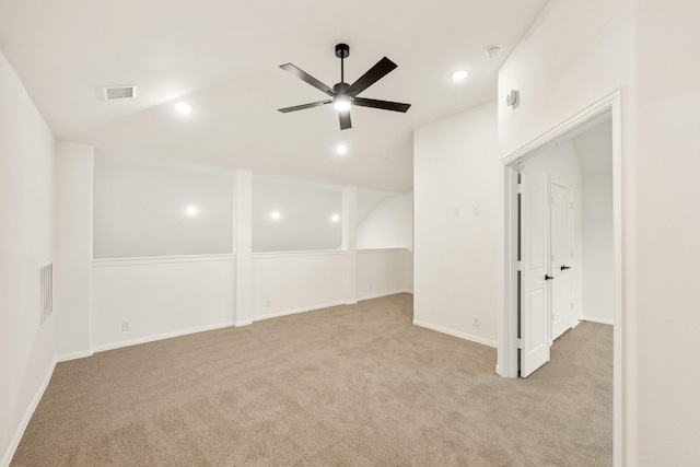 spare room with ceiling fan, light colored carpet, and vaulted ceiling