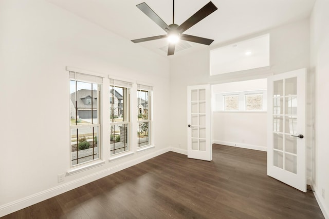 spare room featuring dark hardwood / wood-style flooring, ceiling fan, and french doors