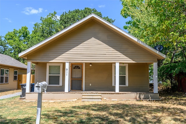 bungalow-style home featuring a porch and a front yard