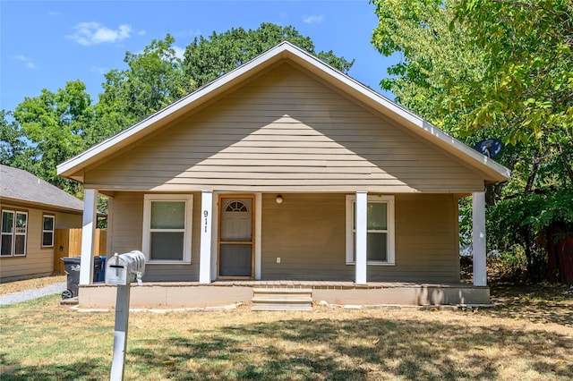 bungalow-style home with a front lawn and covered porch