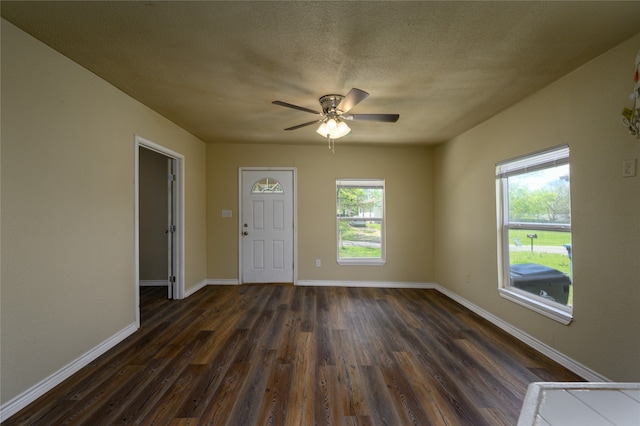 spare room with dark wood-type flooring and ceiling fan