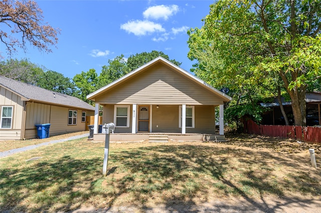 bungalow-style house featuring covered porch and a front yard