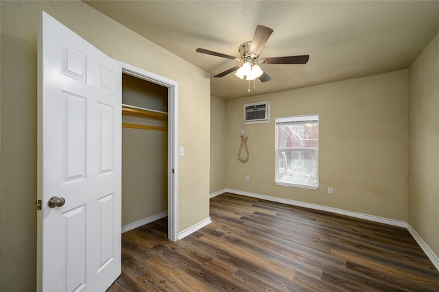 unfurnished bedroom featuring a wall mounted air conditioner, a closet, ceiling fan, and dark wood-type flooring