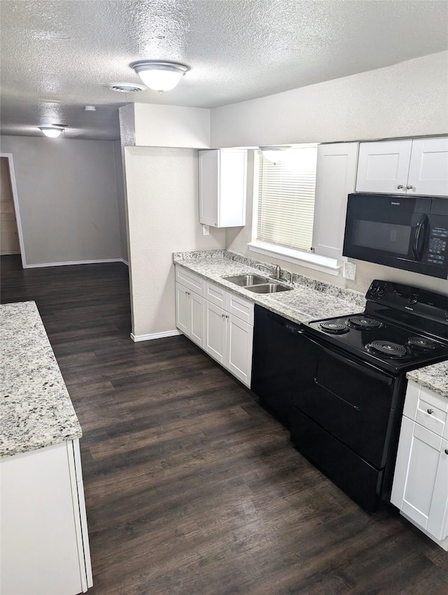 kitchen with dark hardwood / wood-style floors, black appliances, sink, white cabinetry, and light stone counters