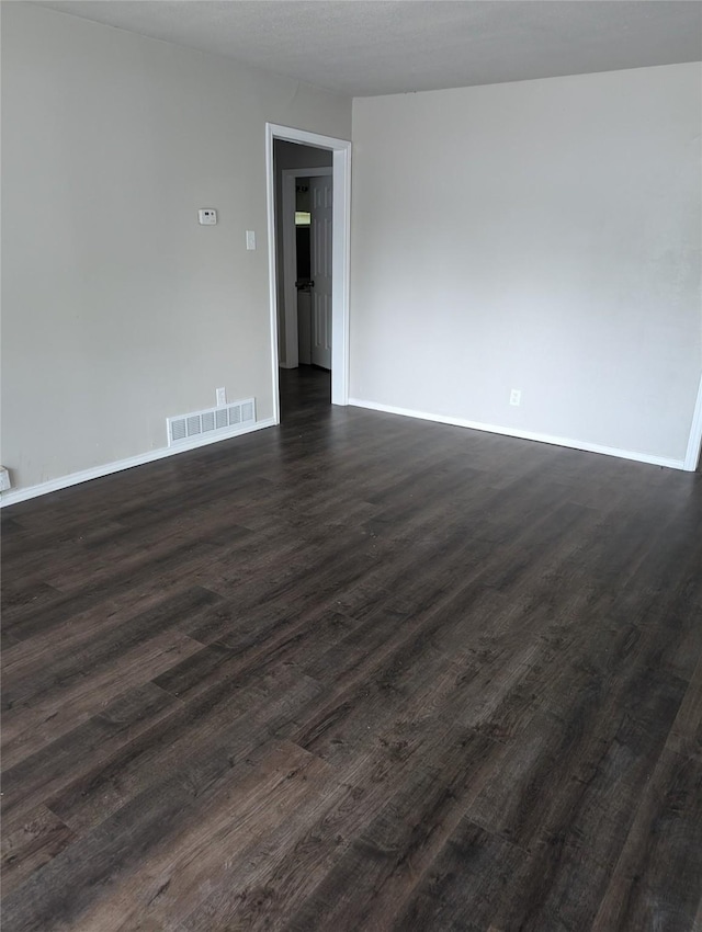 spare room with dark hardwood / wood-style floors