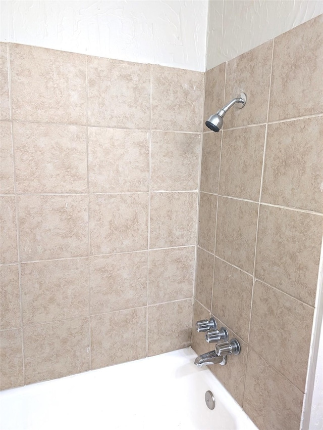 bathroom featuring tiled shower / bath