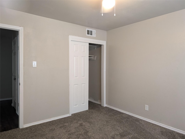 unfurnished bedroom featuring a closet and dark carpet