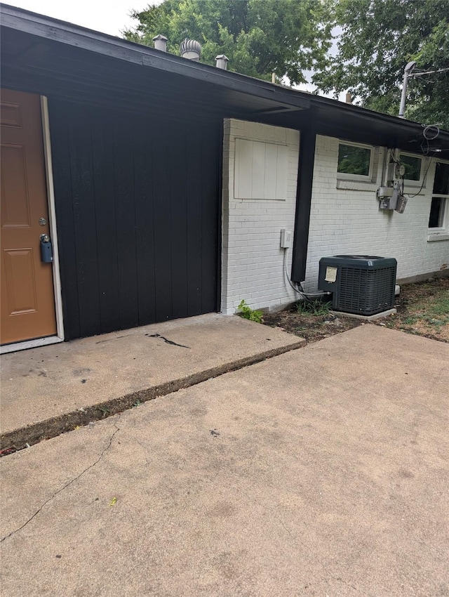 view of exterior entry featuring a patio area and central air condition unit