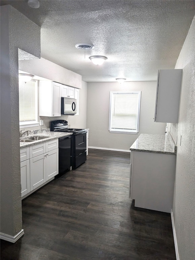 kitchen with black appliances, white cabinets, light stone countertops, and sink