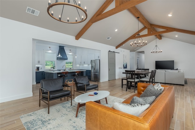 living room with beamed ceiling, a barn door, and light wood-type flooring