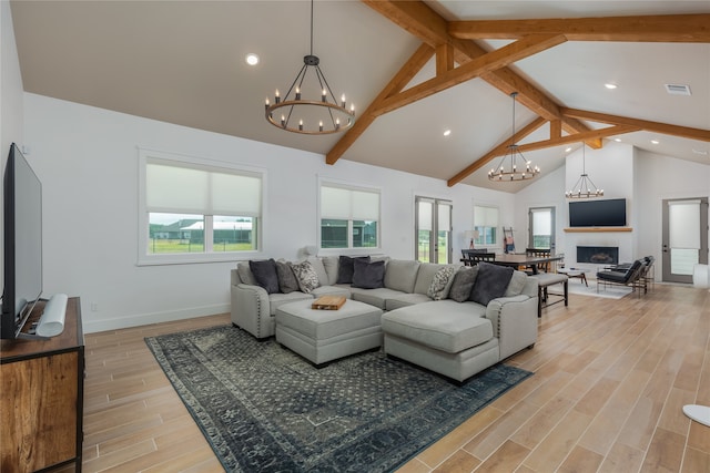 living room featuring high vaulted ceiling, a healthy amount of sunlight, beamed ceiling, and light wood-type flooring