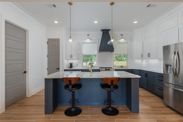 kitchen with appliances with stainless steel finishes, sink, white cabinetry, pendant lighting, and custom exhaust hood