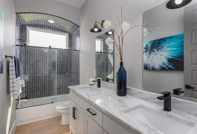 full bathroom featuring toilet, enclosed tub / shower combo, vanity, and wood-type flooring