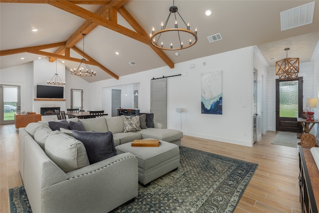 living room with beam ceiling, a barn door, high vaulted ceiling, and light wood-type flooring