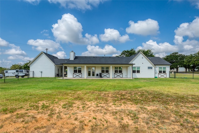 back of house featuring a yard and covered porch