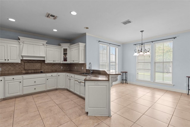 kitchen featuring sink, white cabinetry, black electric stovetop, custom exhaust hood, and kitchen peninsula
