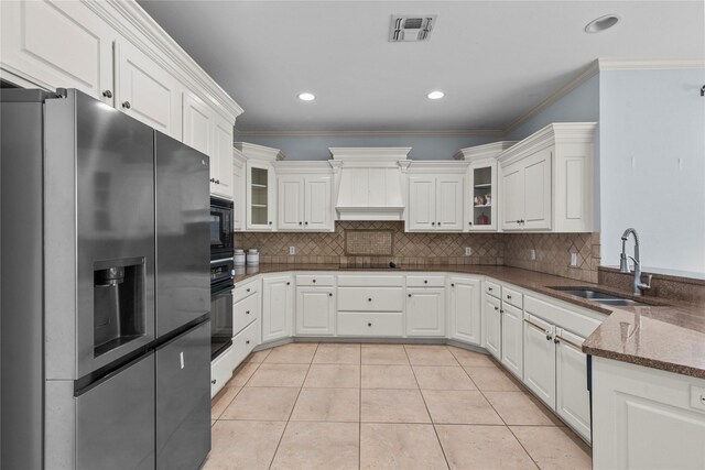 kitchen featuring white cabinetry, sink, light tile patterned floors, black appliances, and crown molding