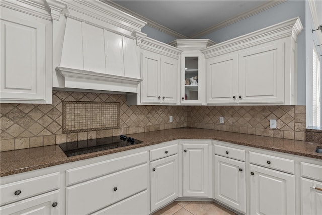 kitchen with crown molding, black electric stovetop, white cabinets, light tile patterned flooring, and custom exhaust hood