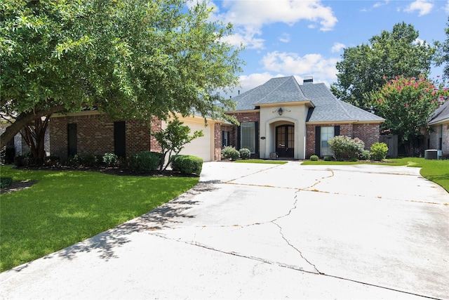 french country style house with a garage, central AC, and a front yard