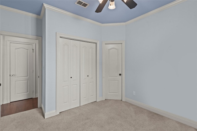 unfurnished bedroom with ornamental molding, carpet floors, and a closet