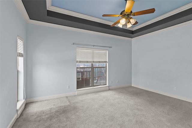 carpeted spare room with ornamental molding, a raised ceiling, and ceiling fan