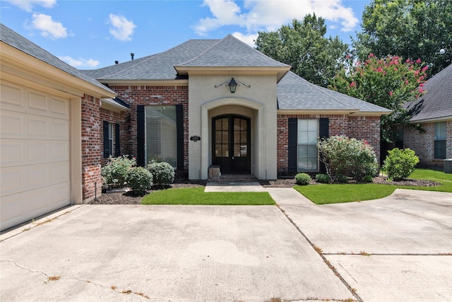 view of front of home with a garage, a front yard, and french doors