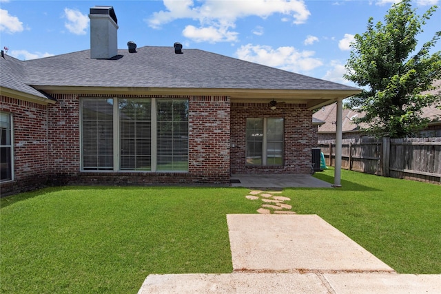 rear view of property with a yard and a patio area
