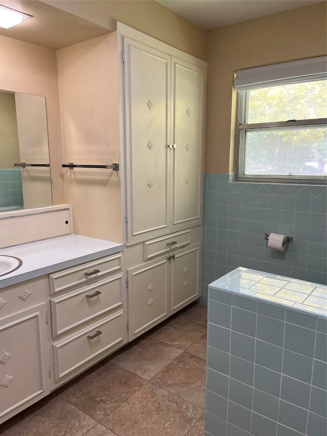 bathroom with tile patterned flooring, tile walls, and vanity