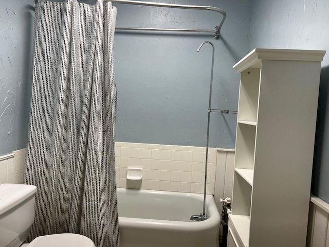 bathroom with shower / bath combination with curtain and toilet