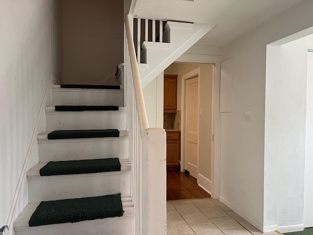 staircase featuring tile patterned flooring