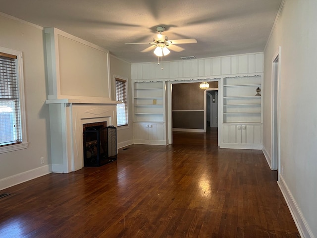 unfurnished living room featuring dark hardwood / wood-style flooring, a textured ceiling, ceiling fan, and built in shelves