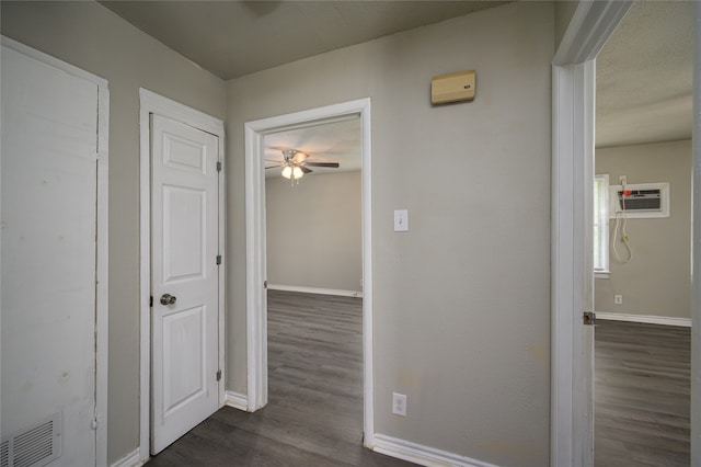 corridor featuring a wall mounted air conditioner and dark hardwood / wood-style flooring