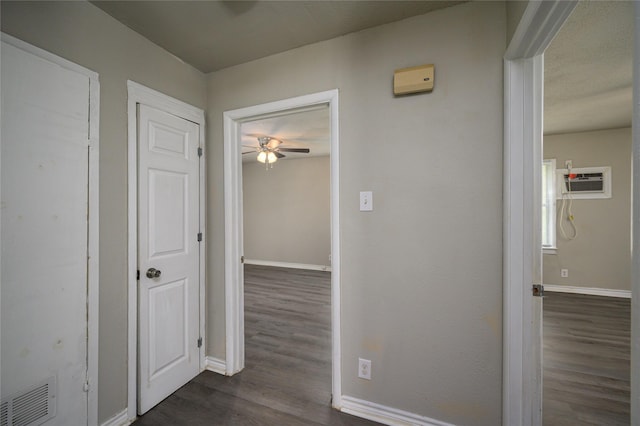 corridor with dark hardwood / wood-style floors and a wall mounted air conditioner