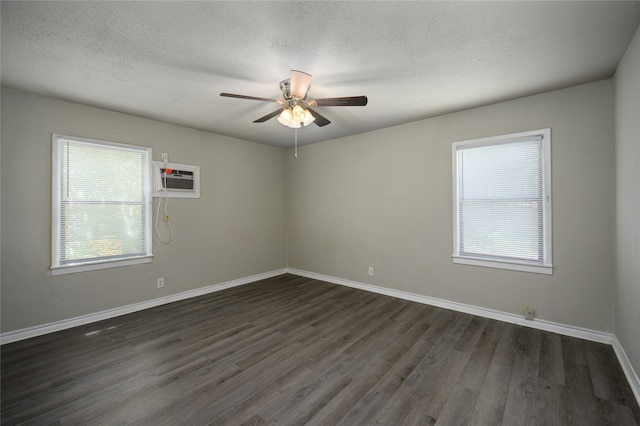 unfurnished room with an AC wall unit, a textured ceiling, ceiling fan, and dark hardwood / wood-style floors