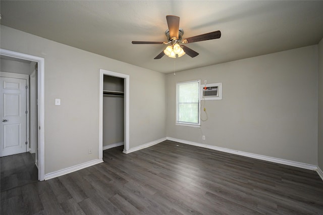 unfurnished bedroom featuring an AC wall unit, dark wood-type flooring, ceiling fan, and a closet