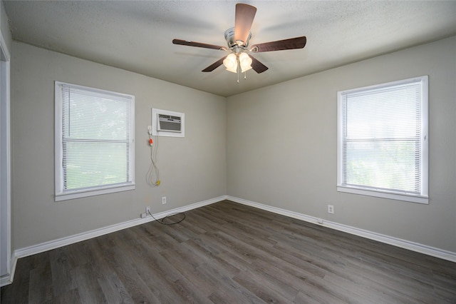 spare room with ceiling fan, a wall unit AC, a textured ceiling, and dark hardwood / wood-style flooring