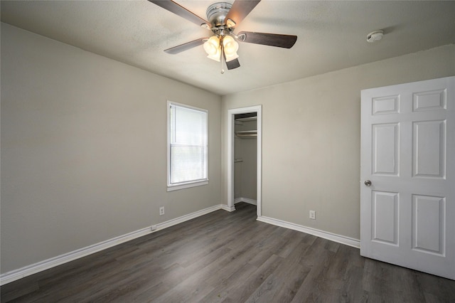 unfurnished bedroom with ceiling fan, dark wood-type flooring, a textured ceiling, and a closet