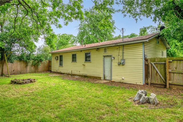 rear view of property featuring a lawn