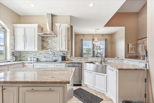 kitchen with wall chimney range hood, a kitchen island, light stone countertops, light tile patterned flooring, and dishwasher