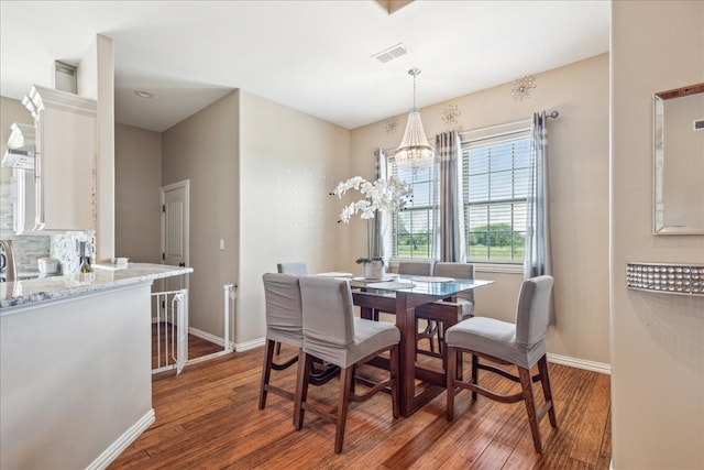 dining space featuring dark hardwood / wood-style floors and a chandelier