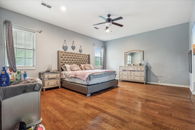 bedroom with hardwood / wood-style flooring, multiple windows, and ceiling fan