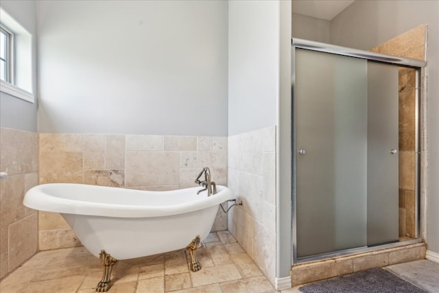 bathroom featuring tile walls, shower with separate bathtub, and tile patterned floors