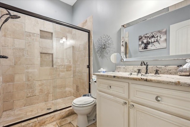 bathroom with tile patterned floors, toilet, vanity, and an enclosed shower